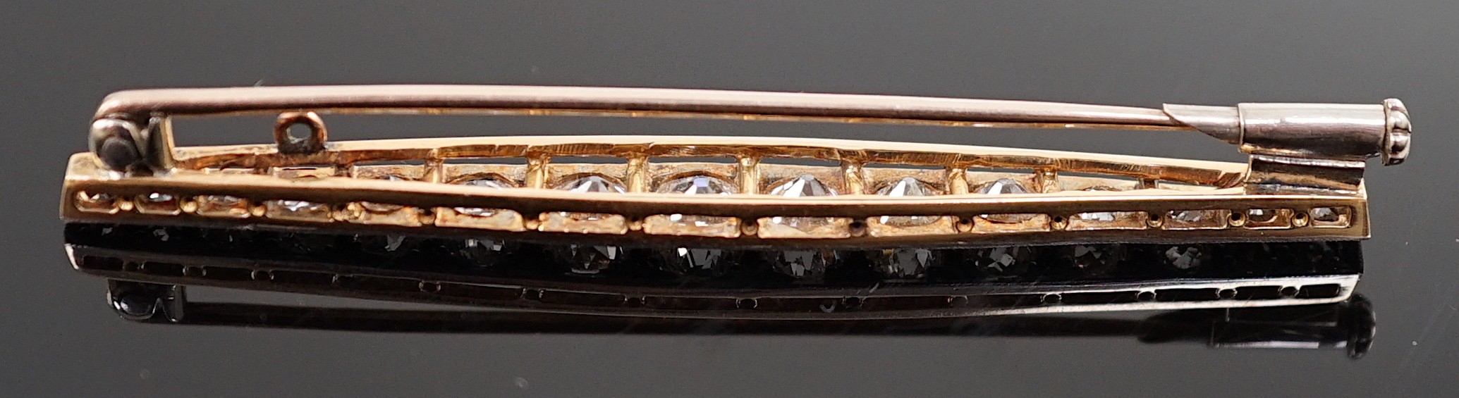 A 1920's gold, platinum and millegrain set graduated old round cut diamond bar brooch